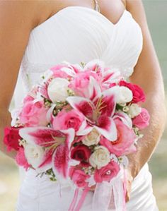 a bride holding a bouquet of pink and white flowers