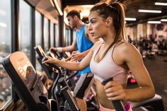 a woman running on a treadmill in a gym with another man looking out the window