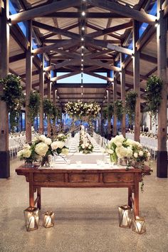 a table with white flowers and greenery is set up for an outdoor wedding reception