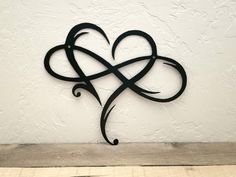 a metal heart on the side of a wall with an intricate design in the middle