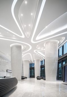 the interior of an office building with white marble floors and columns, along with large windows