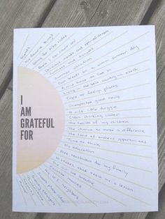 i am grateful for poster on wood background with handwritten text and sunburst