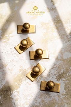 four brass door knobs on a white surface with the name armmac martini