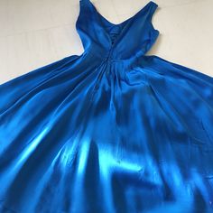 "Sad to be letting thus one go but it's just too big and wasting away in the alteration pile. Gorgeous satin '50s party dress in the most gorgeous shade of cobalt blue! Totally love the wide v-neckline, fitted bodice and waist, full pleated skirt, and center hanging sash detail adorned with scattered matching buttons. Metal zipper closure in the back with an added hook placket. Unlined. Material: Satin, feels like possibly an acetate Condition: A few very tiny pinholes in the skirt, not noticeab Blue Satin V-neck Dress For Party, Blue A-line Satin Evening Dress, Blue Satin A-line Evening Dress, Vintage Satin V-neck Dress, Blue Silk Satin Evening Dress, Blue Formal Dress In 1950s Style, 1950s Style Blue Formal Dress, Blue 1950s Style Formal Dress, 1950s Style Blue Wedding Dress