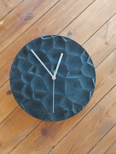 a black clock sitting on top of a wooden floor