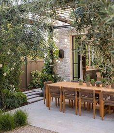 an outdoor dining area with wooden table and chairs