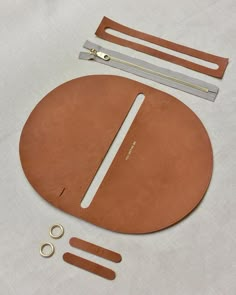 the contents of a round purse laid out on a white tablecloth with zippers