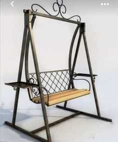 a metal and wood swing chair sitting on top of a white floor with the words ufa - koka ru written below it