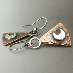 "Looking a bit magical these mixed metal trapezoid moon earrings created from rich, warm copper and sterling silver look as if they might have been worn by a magicians apprentice long ago. Rustic but refined these are a a wonderful pair for their versatility enabling you to wear them with casual clothing or with dressier clothing and special occasions. The copper has a hammered finish while the silver moon is smooth and shiny. The hammered sterling silver ring at the top adds more interest to th Copper Handmade Earrings, Copper And Silver Jewelry, Metal Earrings Handmade, Hammered Metal Jewelry, Lunar Jewelry, Small Silver Hoop Earrings, 925 Earrings, Hammered Jewelry, Copper Jewellery