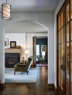 a living room filled with furniture and a fire place in the middle of a hallway