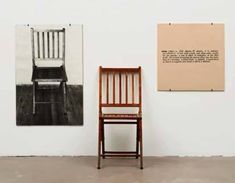 a wooden chair sitting in front of two pictures on the wall next to each other