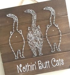 three cats made out of string on a wooden sign