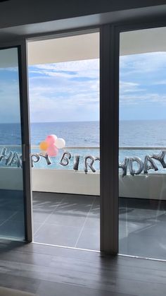 an open door with the words happy birthday written on it and balloons floating in the air