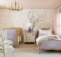 a bedroom decorated in pink and white with flowers on the wall, dressers and bed