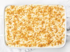 a casserole dish filled with cream and crumbs on top of a white cloth