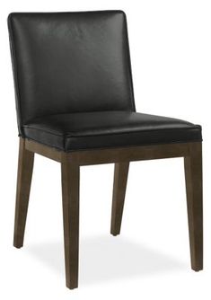 a black leather dining chair with wooden legs