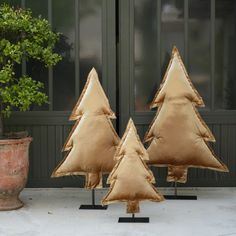 three small christmas trees made out of burlock