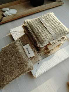 two pieces of cloth sitting on top of a wooden cutting board next to a knife