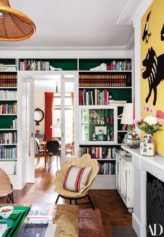 a living room filled with furniture and bookshelves covered in lots of bookcases