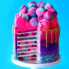 the cake is decorated with colorful icing and sprinkles on blue background