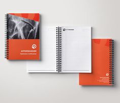 two spiral notebooks with an orange cover are next to each other