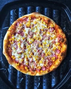 a pizza sitting on top of a grill covered in toppings