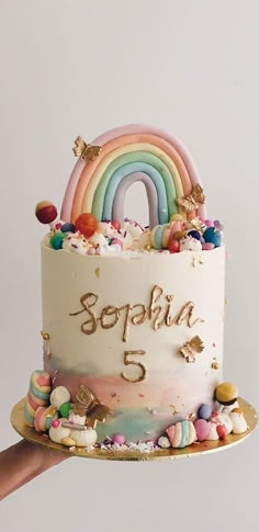 there is a birthday cake with rainbows and stars on the top that says soppia 5