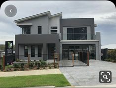 a grey house with a black fence and gate