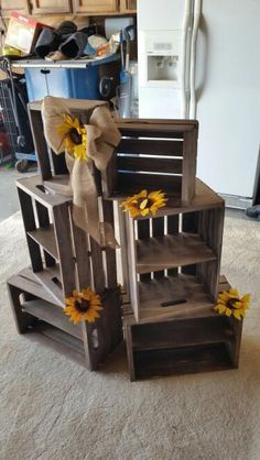 three wooden crates stacked on top of each other with sunflowers tied to them