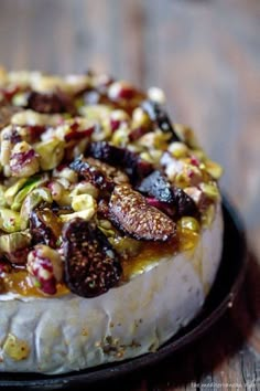 a baked cheese dish with figs and nuts on top