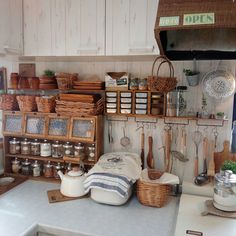 a kitchen with lots of pots and pans on the wall, hanging utensils