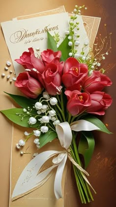 a bouquet of red flowers sitting on top of a card