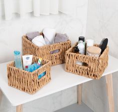 two wicker baskets sitting on top of a white counter next to a towel rack