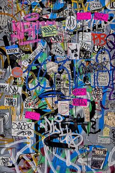 a wall covered in lots of graffiti and stickers