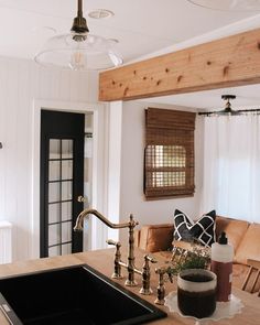 a kitchen counter with a sink, faucet and window in the back ground