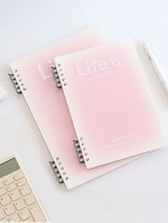 two notebooks with the words life is on them next to a calculator