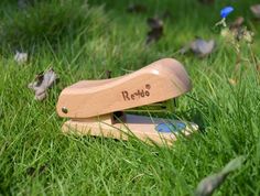 a wooden toy sitting in the grass with its name engraved on it's blade