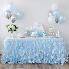 a table topped with cake and balloons on top of a hard wood floored floor