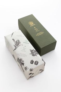 a green box sitting next to a white and black paper wrapped in floral designs on it