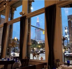 an empty restaurant with large windows overlooking the city