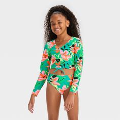 They'll gear up for sunny outdoor adventures in tropical style with this 'Abstract Blossoms' Floral Printed Rash Guard Set from art class™. The swimsuit set includes a solid bikini top, a bikini bottom and a long-sleeve rash guard with topstitching to help them create tons of swim looks and stay comfortable covered after swimming. Both the rash guard and swim bottoms are covered with vibrant floral print for a tropical vibe, and the top comes with crisscross back straps for an elevated look. Designed with 4-way stretch and elastic at the leg openings to help them move in comfort, this rash guard swimsuit set features UPF 50+ rated fabric to offer protection from the sun's UV rays. Welcome to art class™, where style is what you make it. Summer Swimsuit Outfits, Rash Guard Swimwear, Rashguard Swimsuit, Tropical Style, Girls Sweet, Swimsuit Set, Swimwear Sets, Kids Outfits Girls, Drop Earring