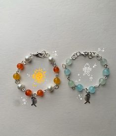 two bracelets with charms on them sitting next to each other