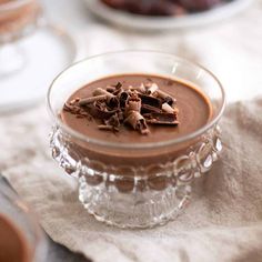 a glass bowl filled with chocolate pudding on top of a table