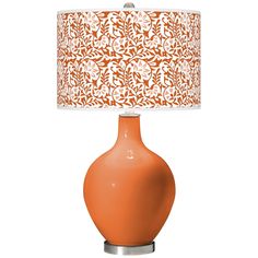 an orange table lamp with a white shade on the bottom and a floral design on the top