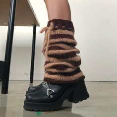 a woman's legs wearing black and brown knitted socks with chains on them