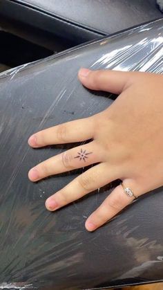 a person's hand with a small tattoo on it