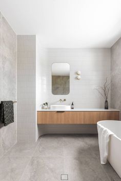 a bathroom with a tub, sink and mirror