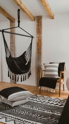 a hammock hanging from the ceiling in a room with black and white decor