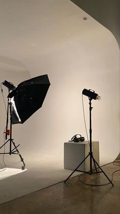 an empty studio with two lights and one light on the ground in front of it