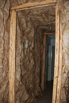 an open door leading into a room with rock walls and wood trimmings on the walls